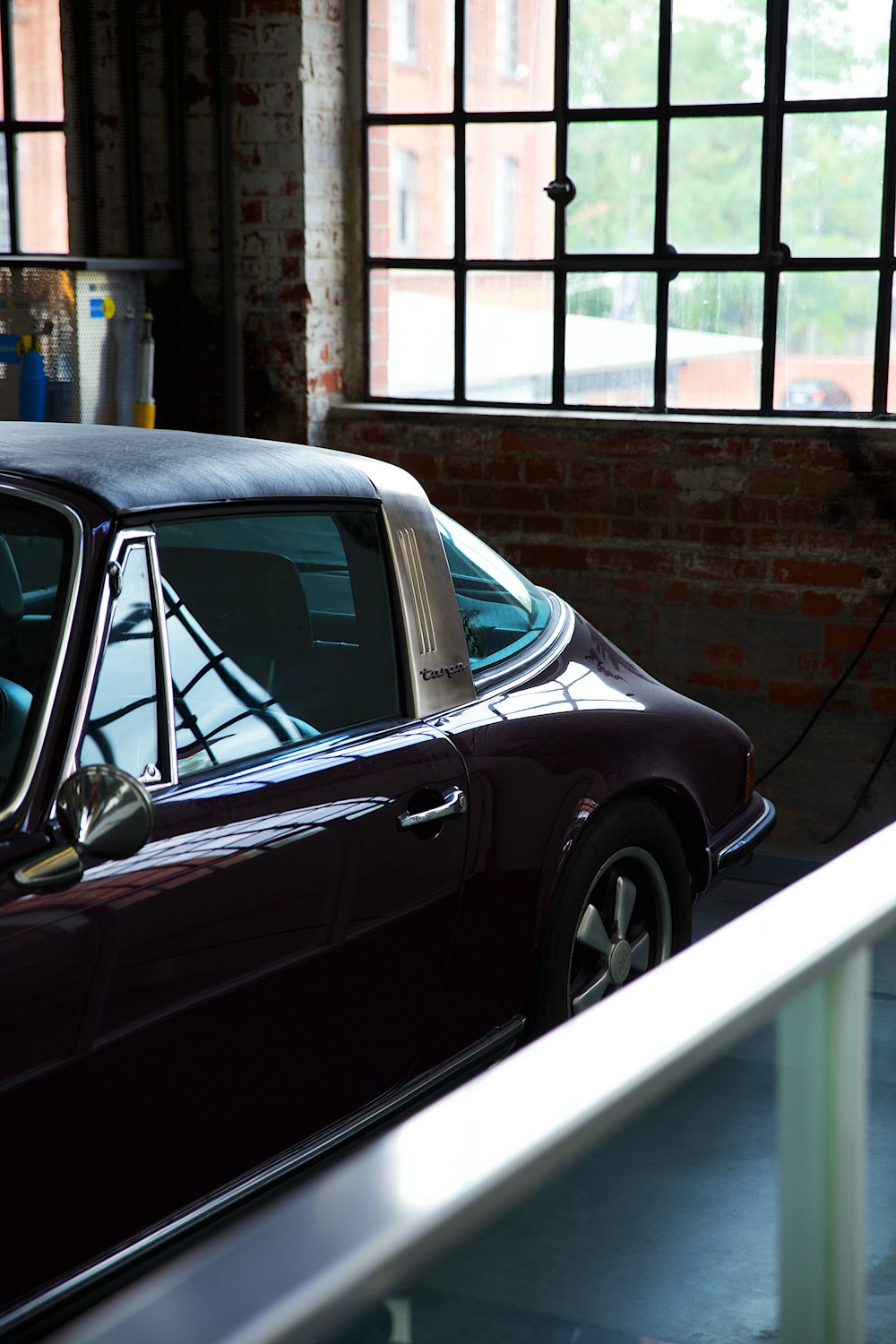 a purple car parked in a garage next to a window