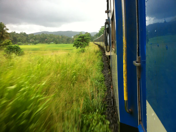 A scenic coach winding through lush green hills under a clear blue sky.