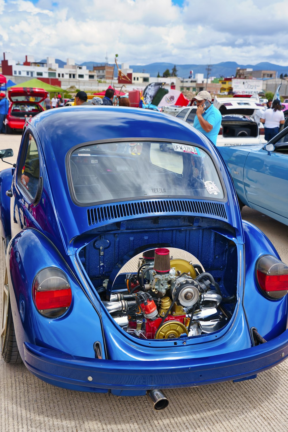 a blue vw bug parked in a parking lot