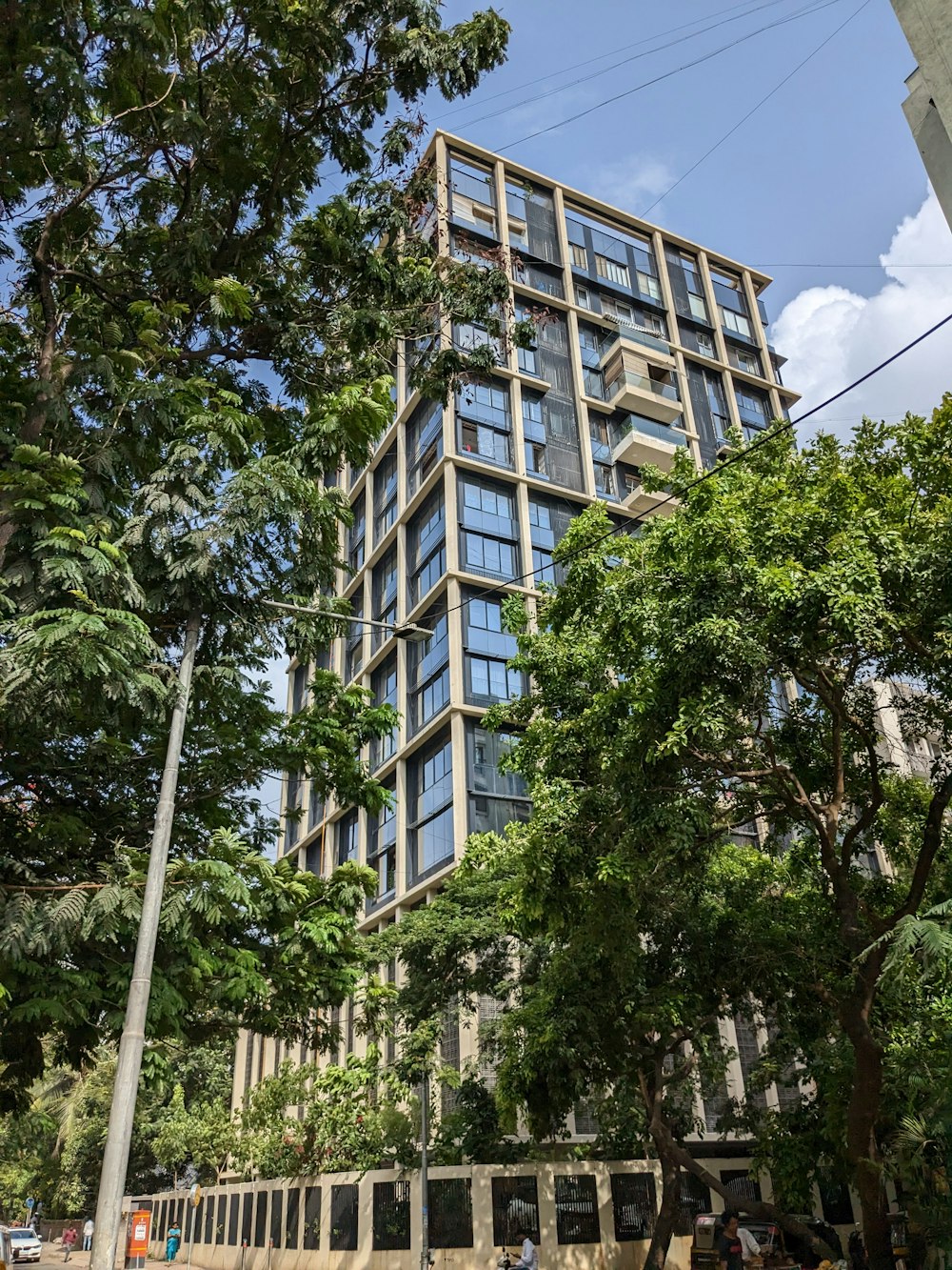 a tall building with lots of windows next to trees