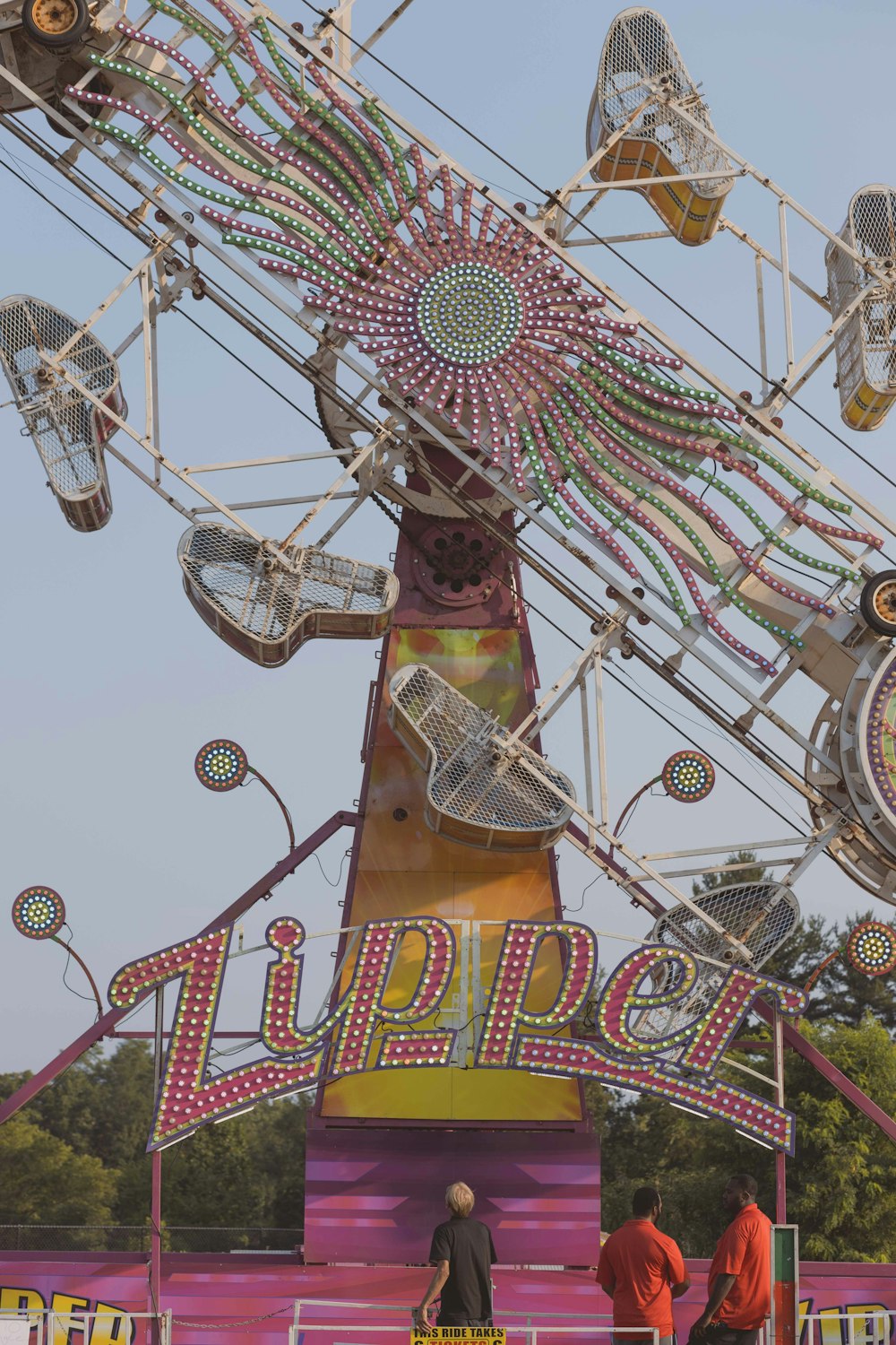 a carnival ride with people standing around it