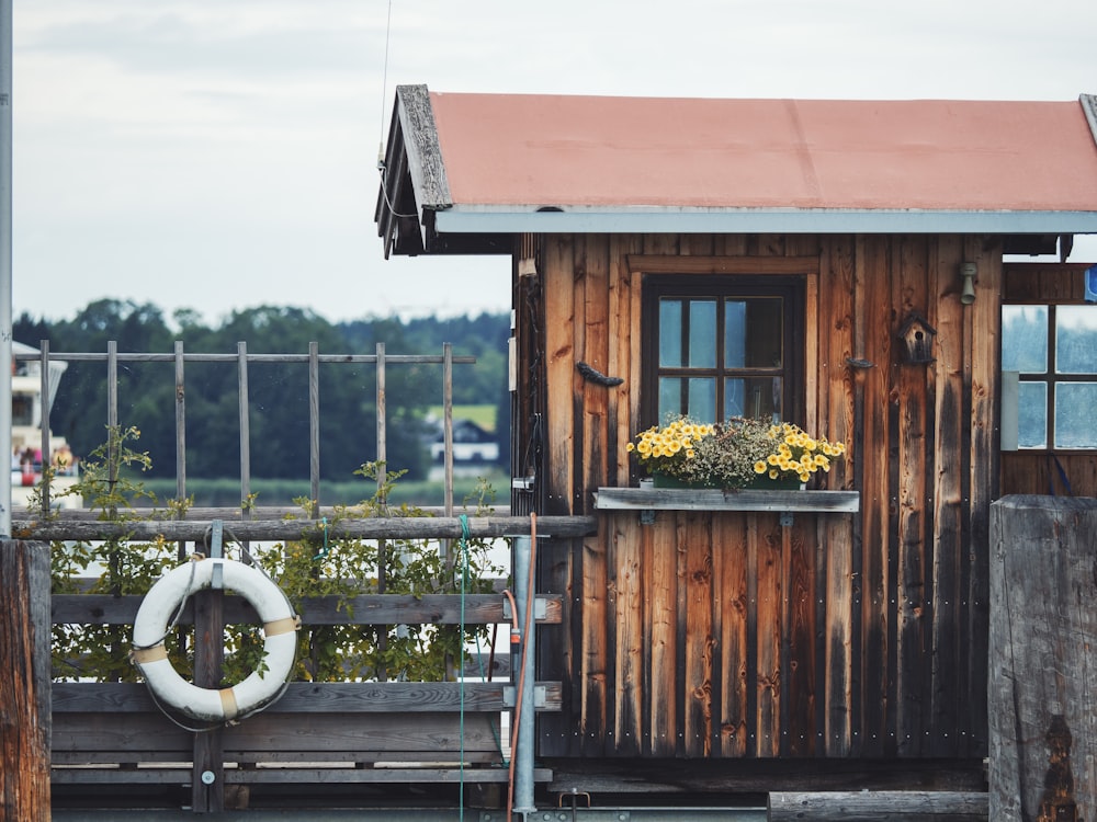 a small wooden building with a boat in the background