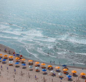 a group of people on a beach with umbrellas