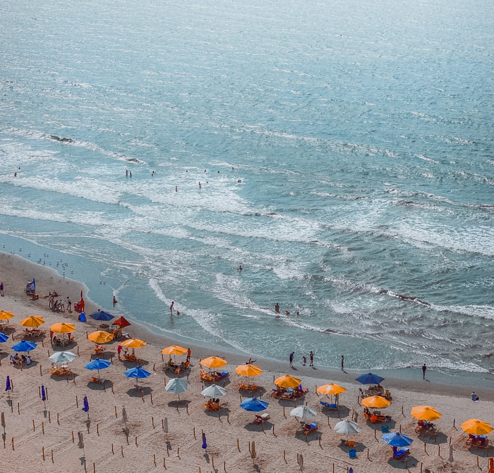 a group of people on a beach with umbrellas