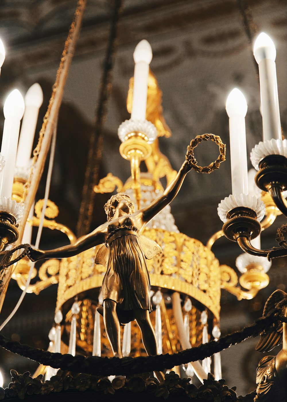 a chandelier with a statue of a woman holding a candle