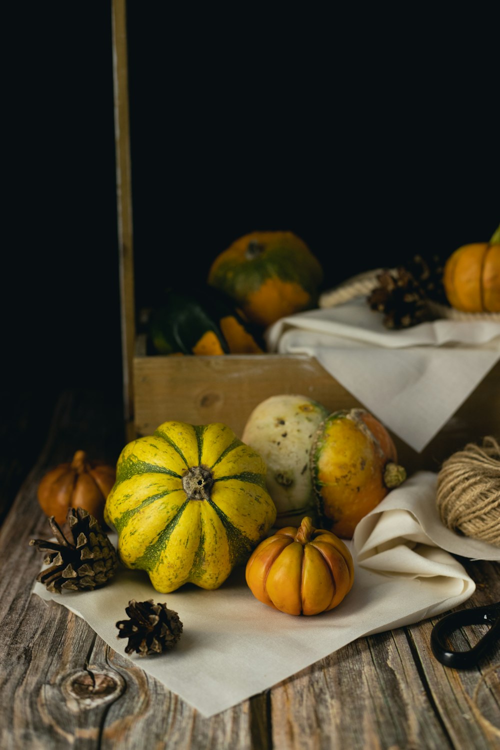 a wooden table topped with lots of different types of pumpkins