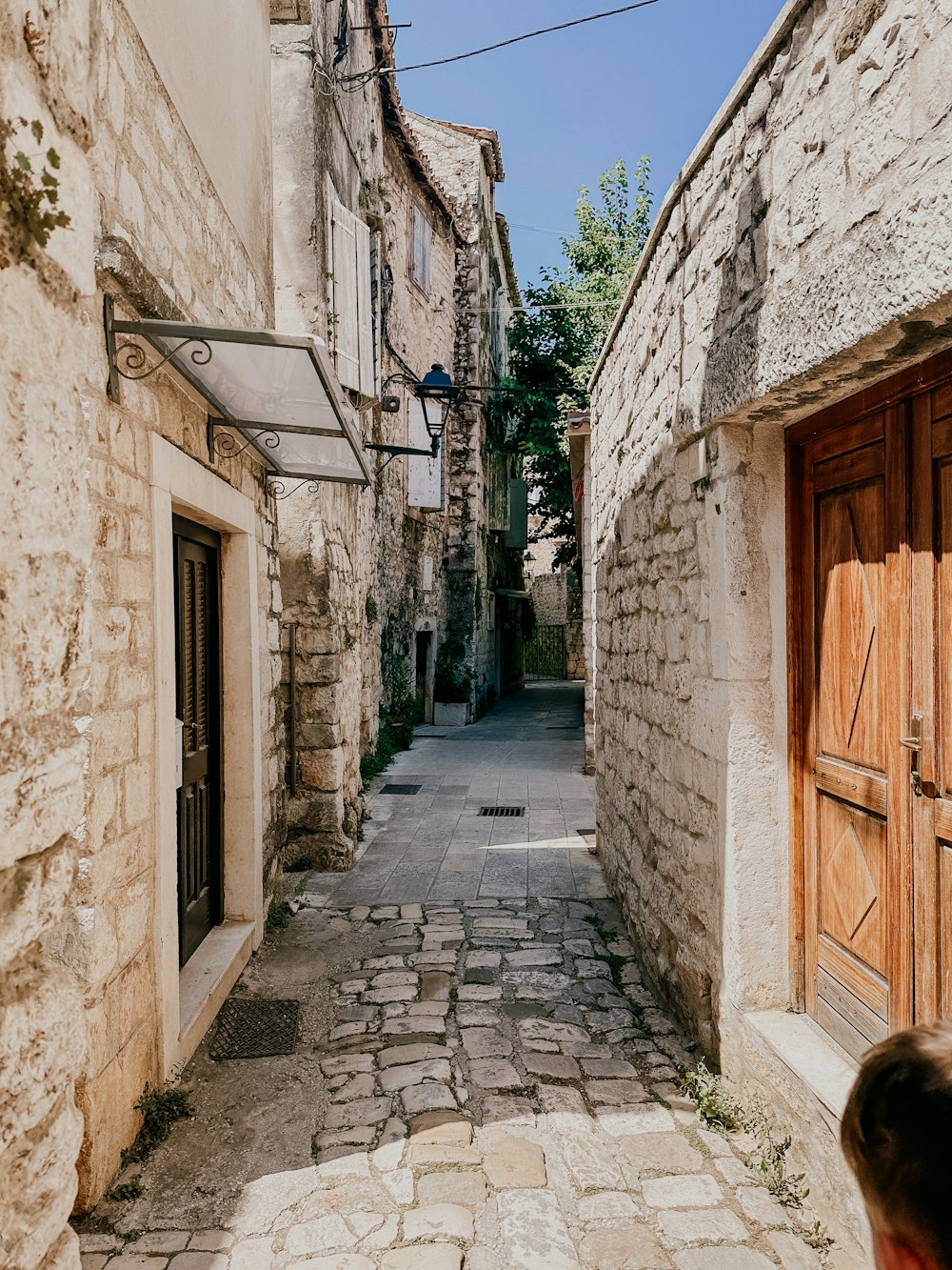 a narrow cobblestone street lined with stone buildings