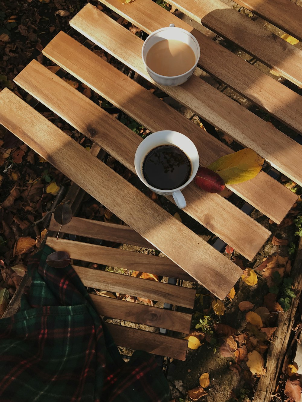 a cup of coffee sitting on top of a wooden table