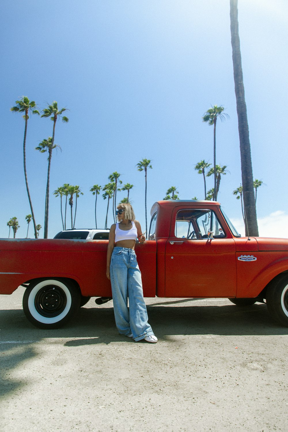 a woman standing next to a red truck