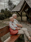 a man and a woman sitting on a wooden bench