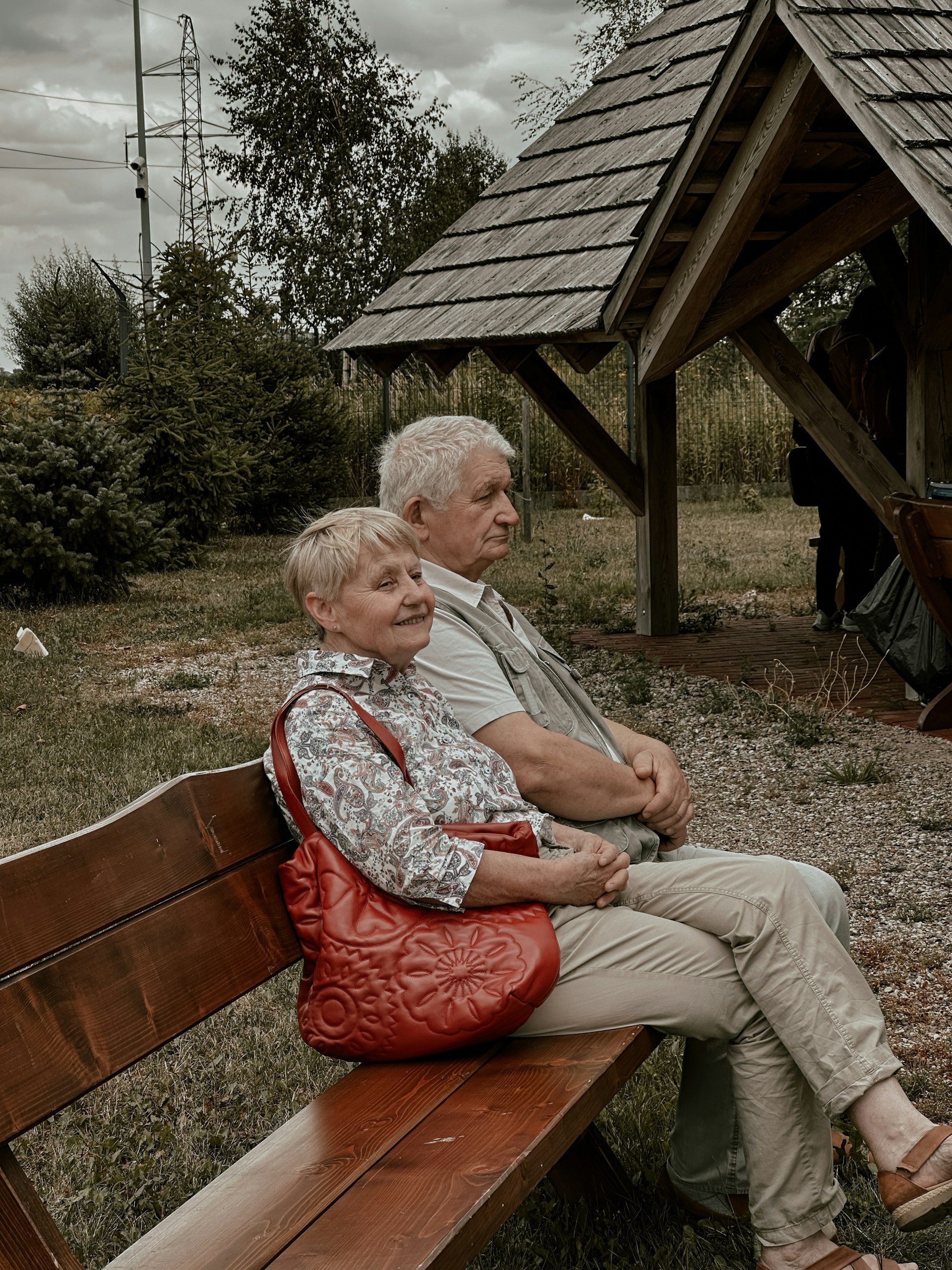 a man and a woman sitting on a wooden bench