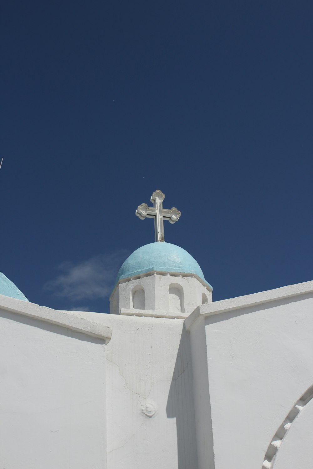 a white building with a blue dome and a cross on top