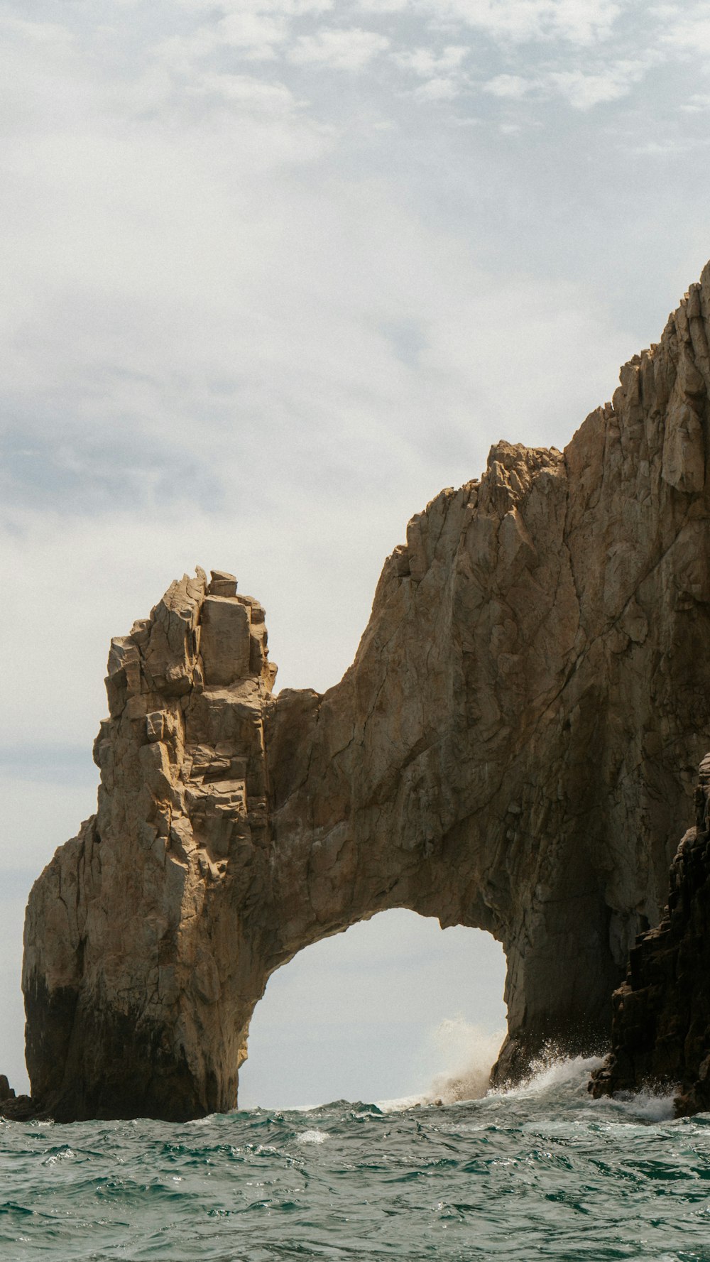 a large rock formation in the middle of the ocean