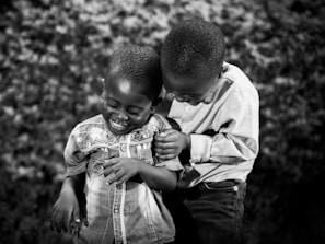 A joyful moment of siblings sharing a playful hug at home.