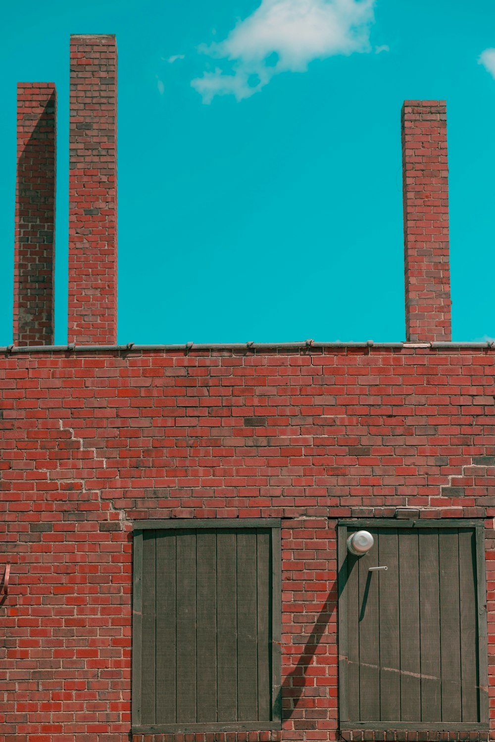 a red brick building with two windows and a street light