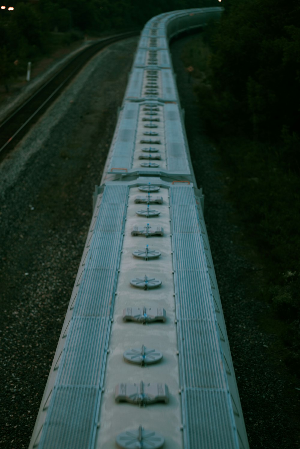 a long train traveling down train tracks next to a forest