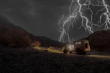 Snapshot of a rugged storm chasing vehicle branded with sponsor logos.