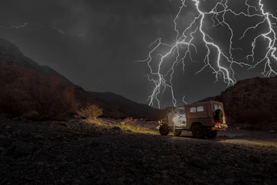 Snapshot of a rugged storm chasing vehicle branded with sponsor logos.