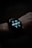 A close-up view of a smartwatch displaying the time, date, battery percentage, heart rate, and step count on its digital screen. The watch is worn on a wrist, and the background is dark, emphasizing the illuminated display.