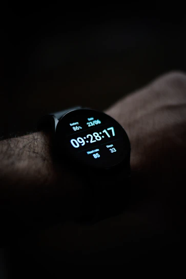 A sleek smartwatch on a wrist displaying fitness tracking, illuminated by natural daylight