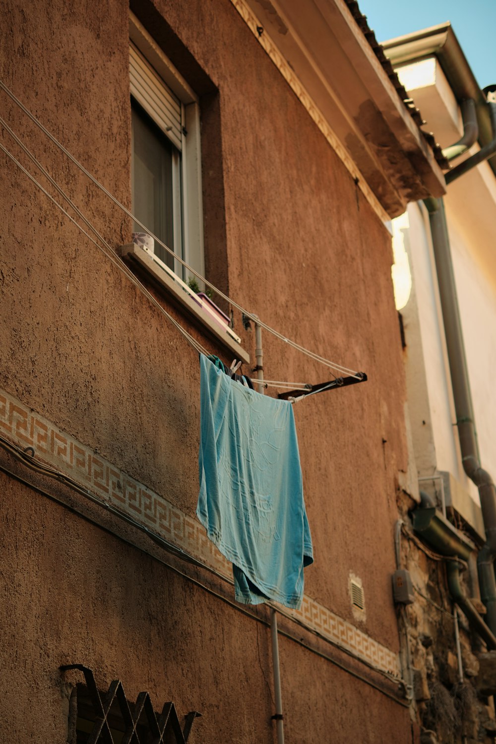 a blue shirt hanging on a clothes line next to a building