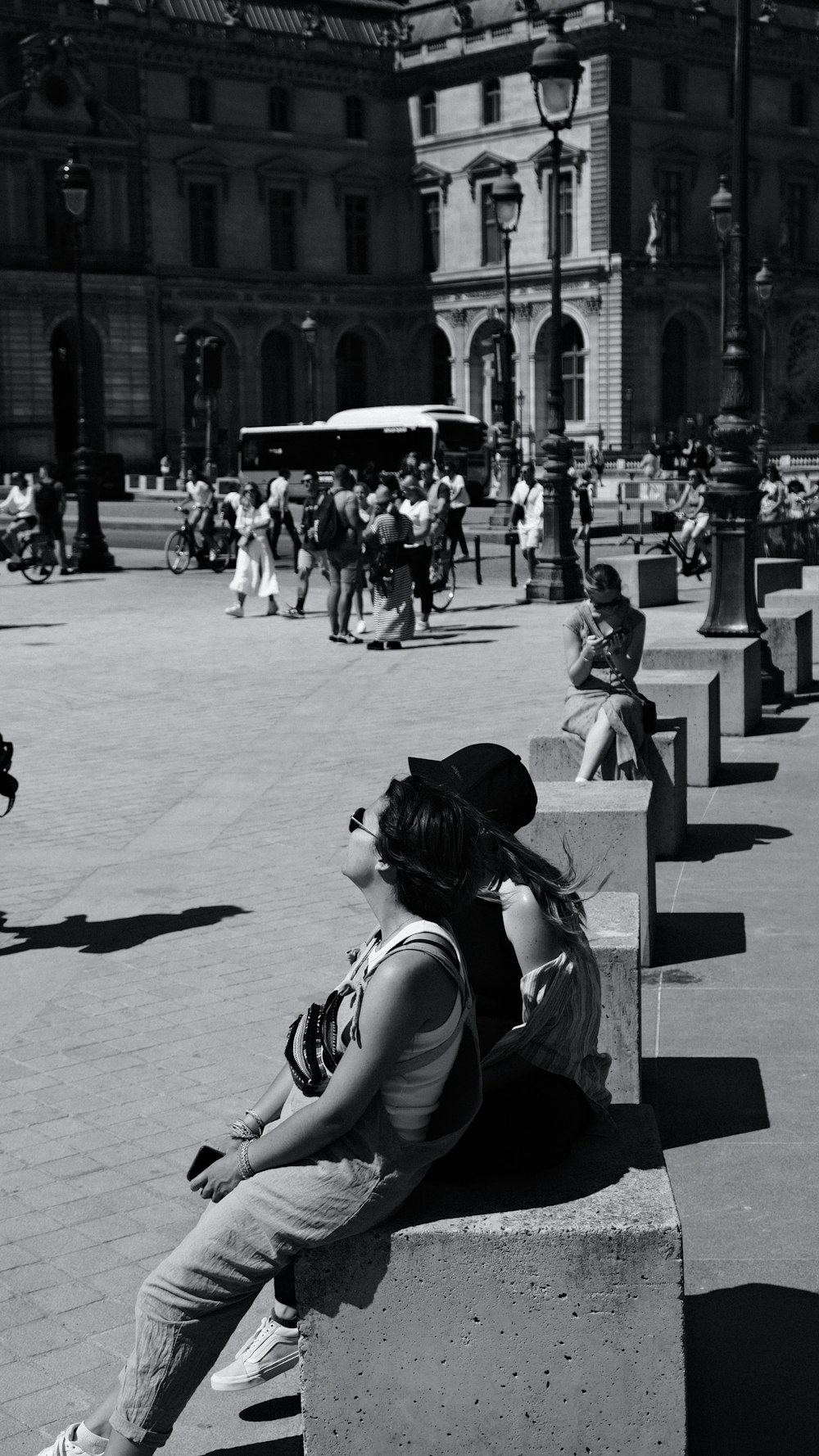 a black and white photo of a woman sitting on a bench