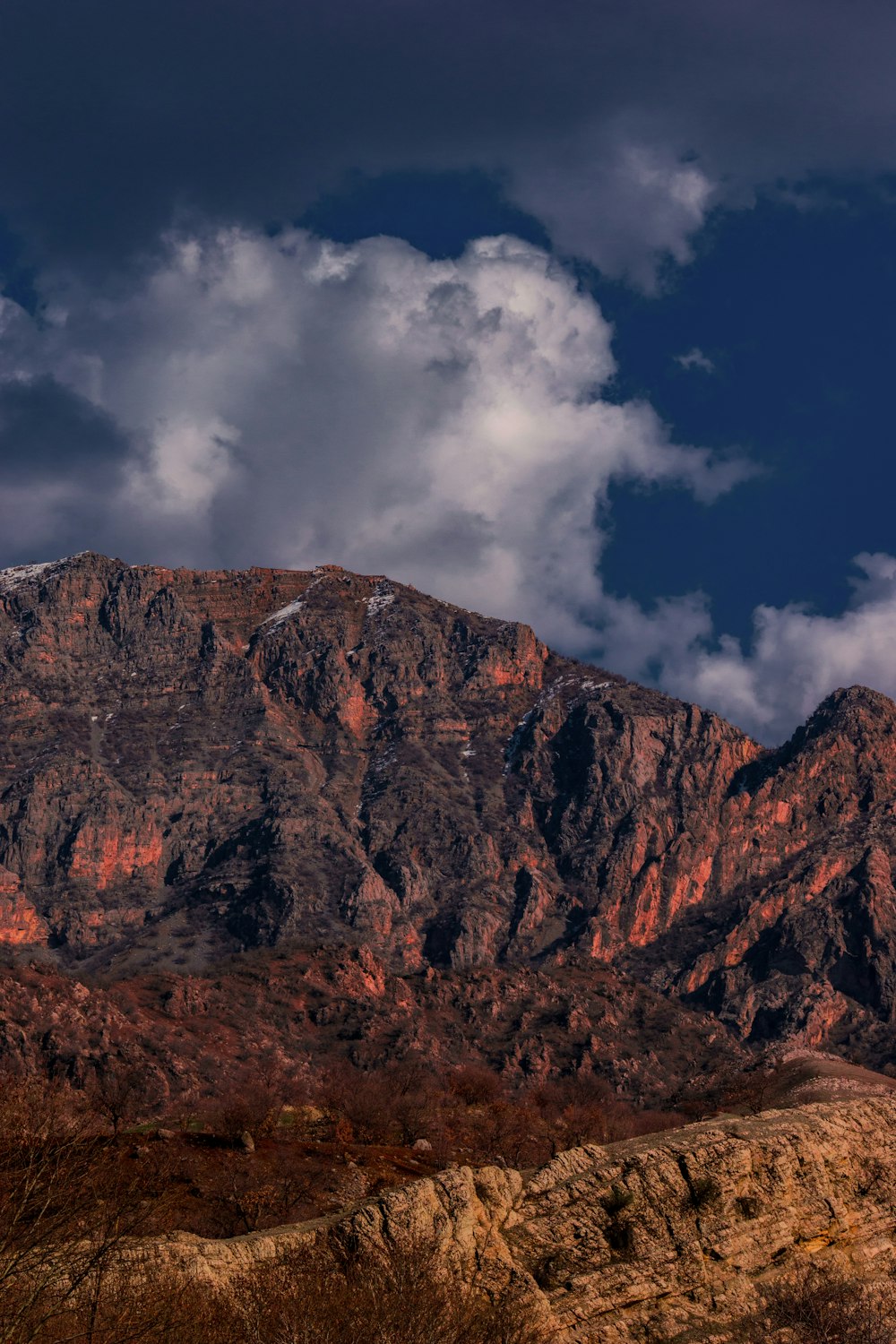 a mountain range with a few clouds in the sky