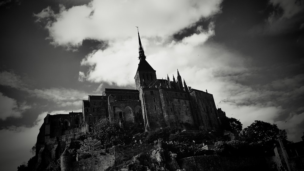 a black and white photo of a castle on a hill