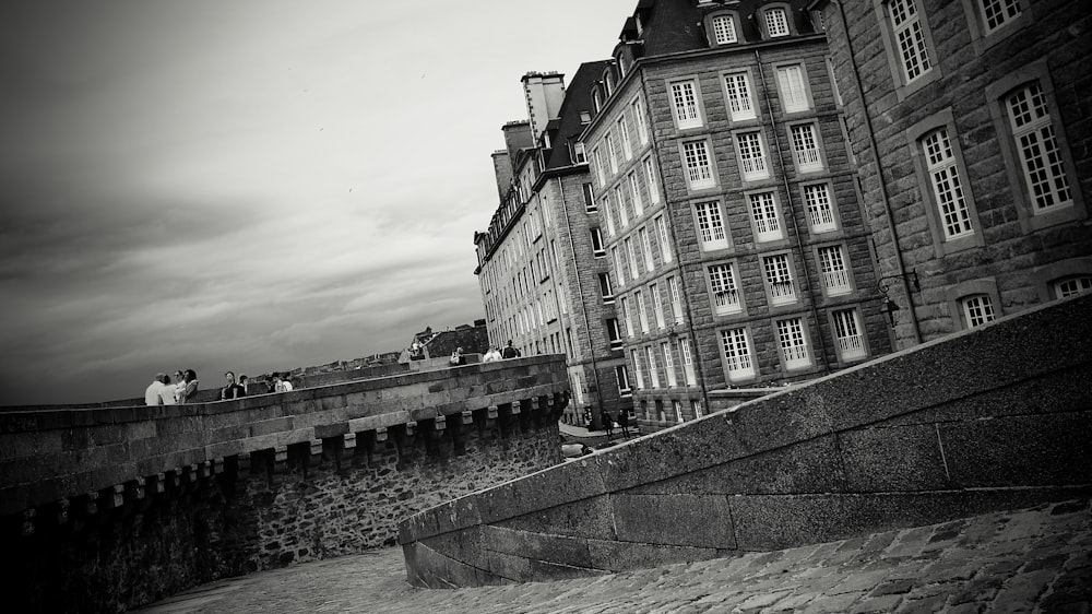 a black and white photo of people on a bridge