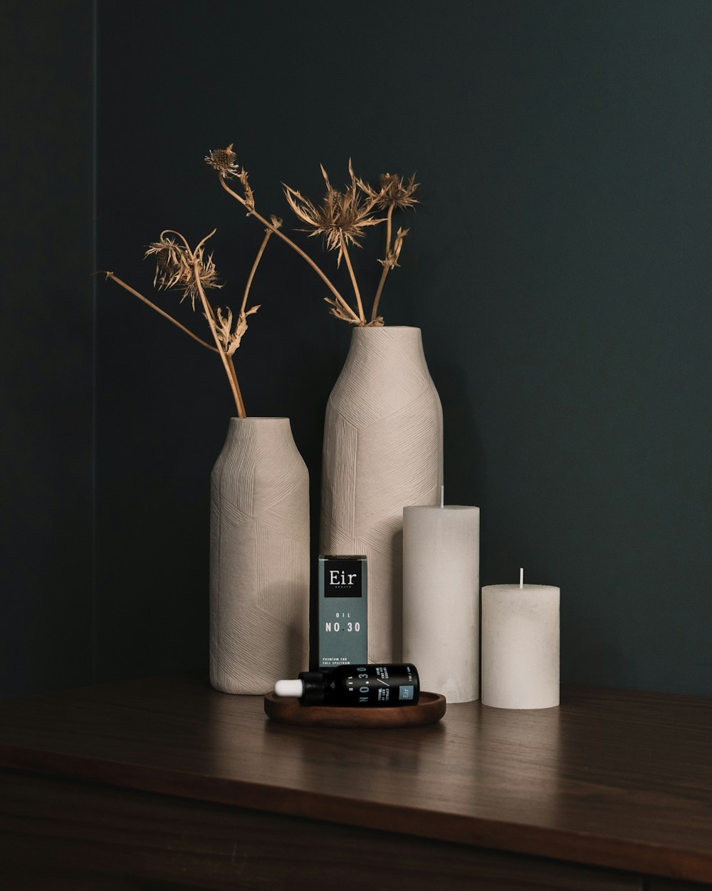 a wooden table topped with vases and candles