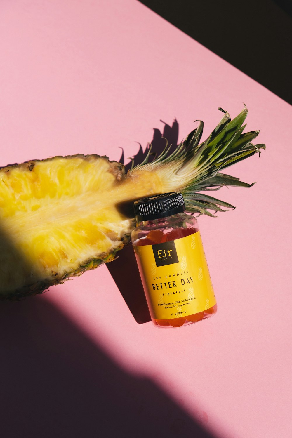 a pineapple next to a bottle of vitamin oil
