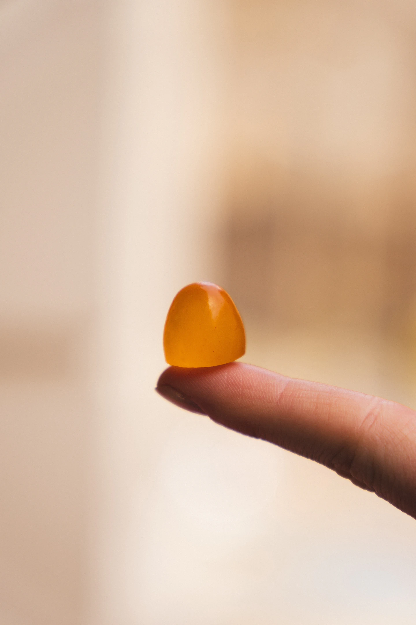 An orange gummy held in the palm