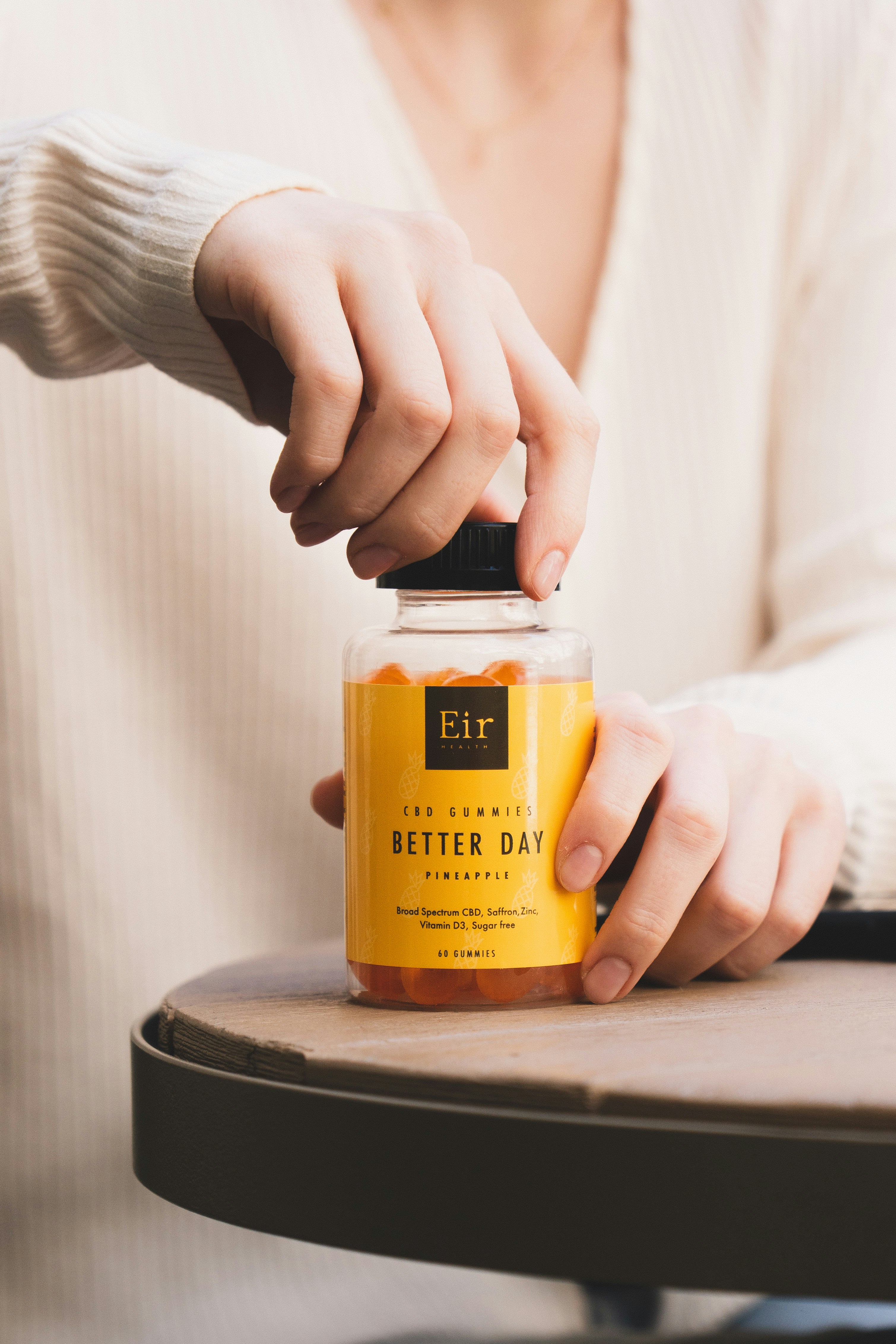 한 사람이 식탁 위에 음식 한 병을 들고 있다