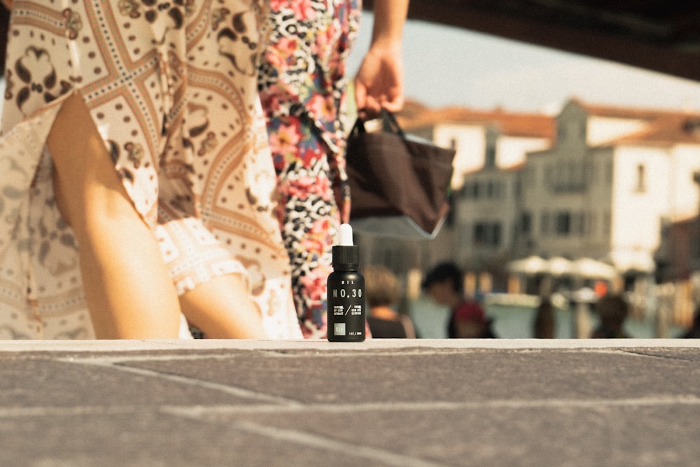 a woman walking down a street next to a bottle of perfume