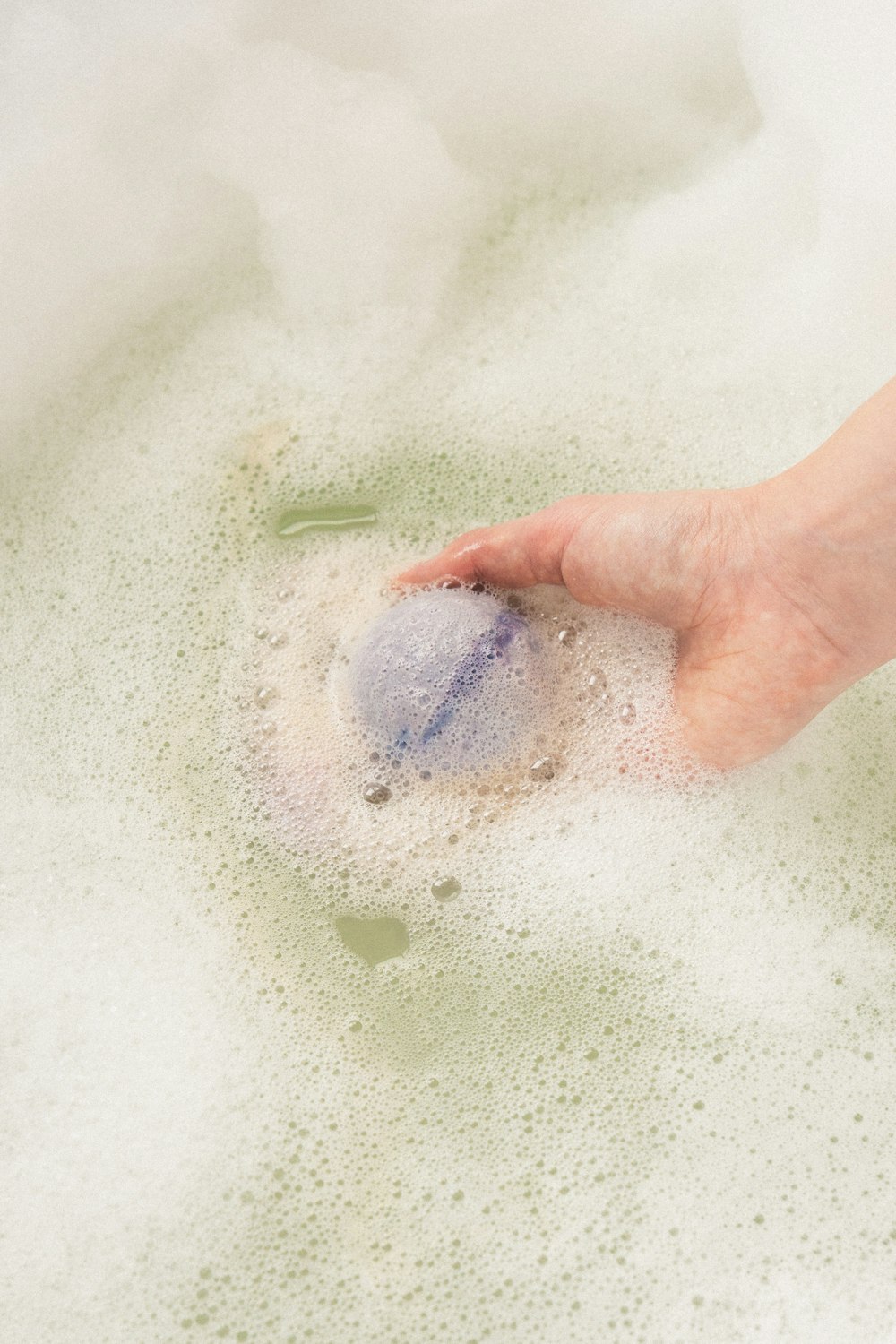 a person's hand in a bath of water