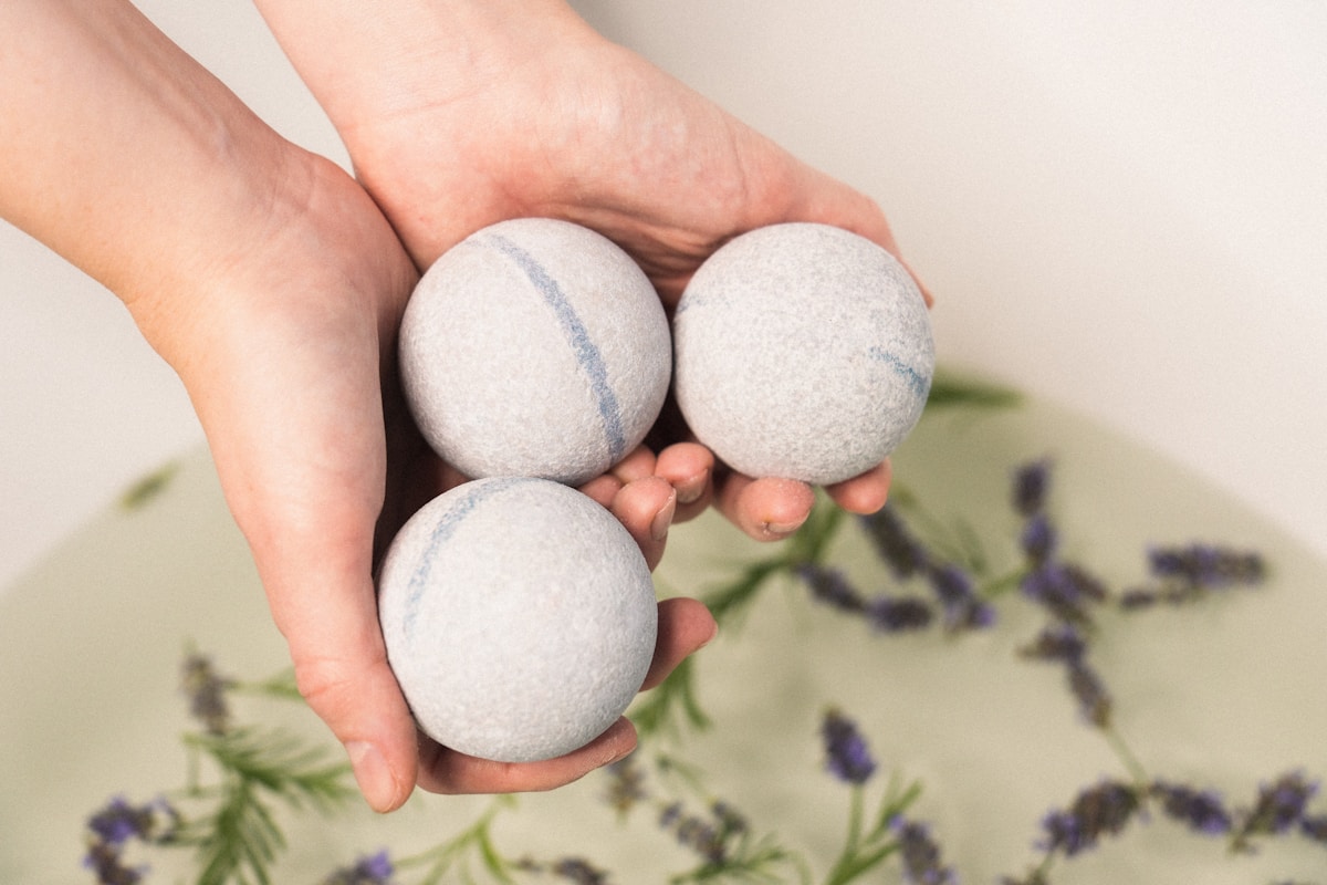 a-person-holding-three-balls-in-their-hands-CX_vgt1fG7c collection background image