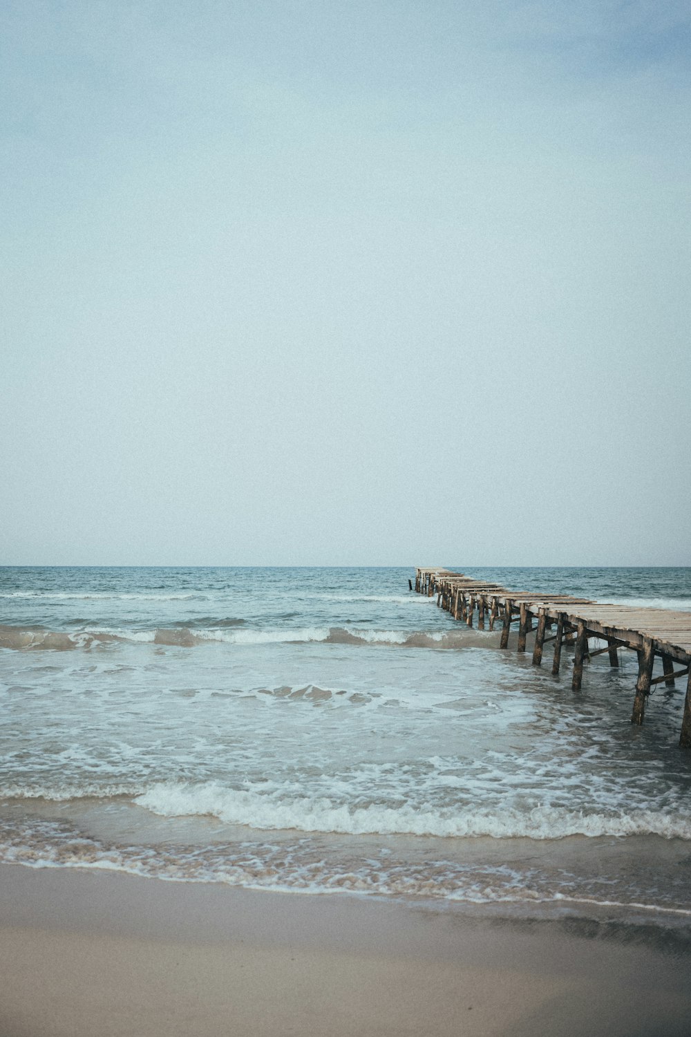 a long pier stretches out into the ocean