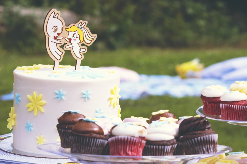 a close up of a cake and cupcakes on a table