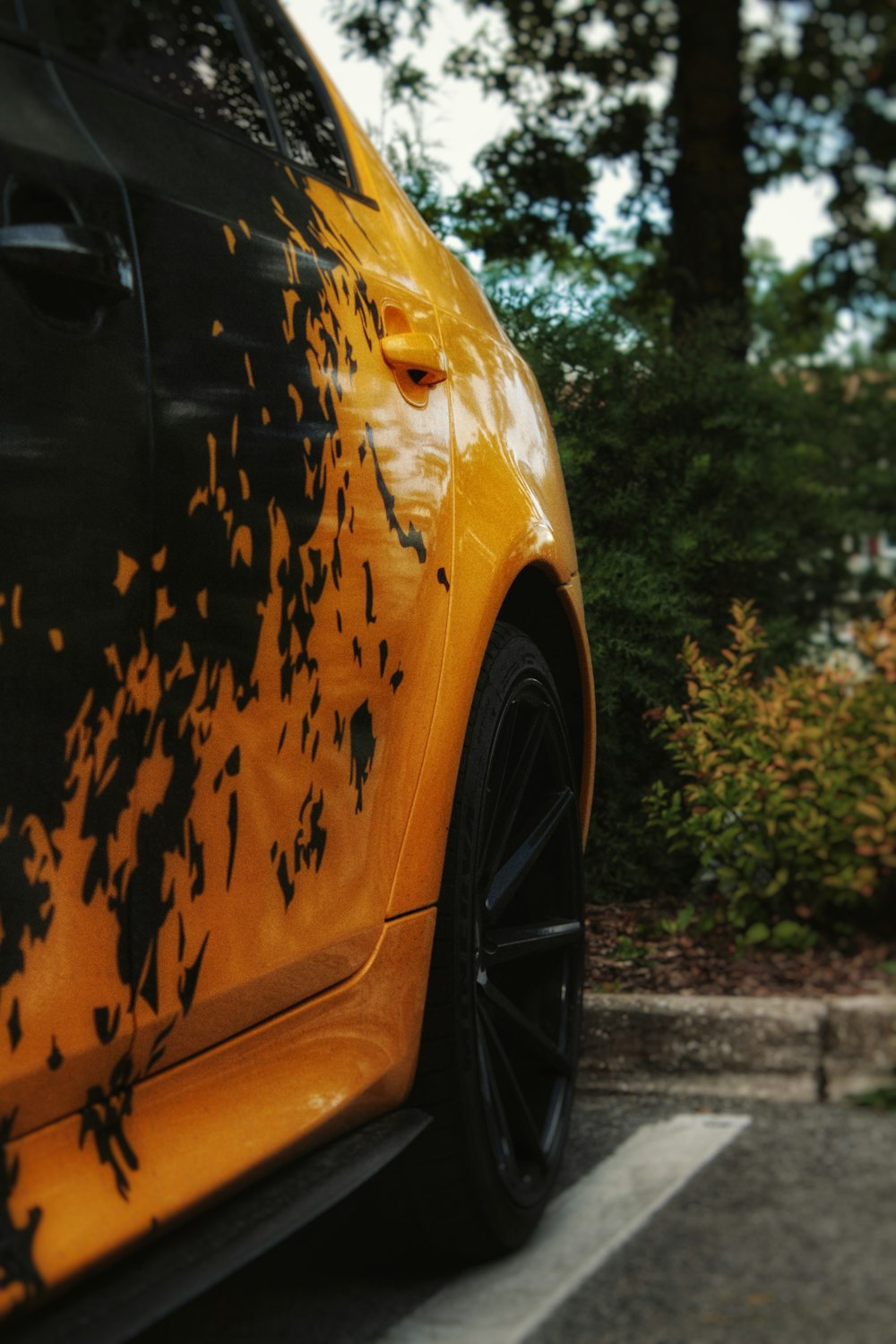 a close up of a yellow car parked in a parking lot