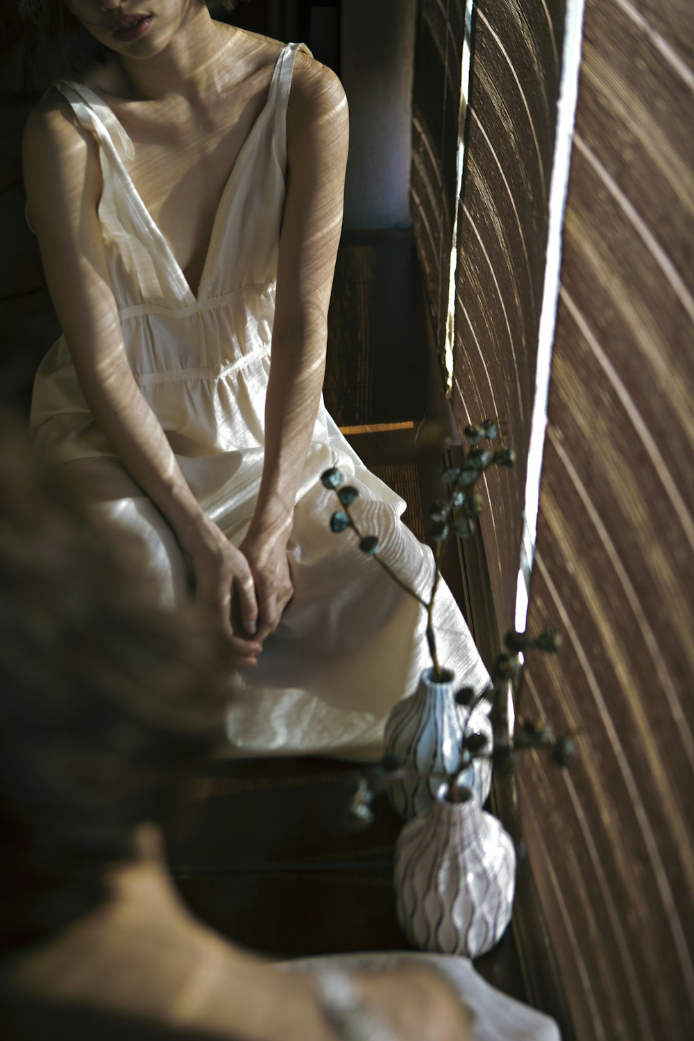 a woman in a white dress sitting on a bench