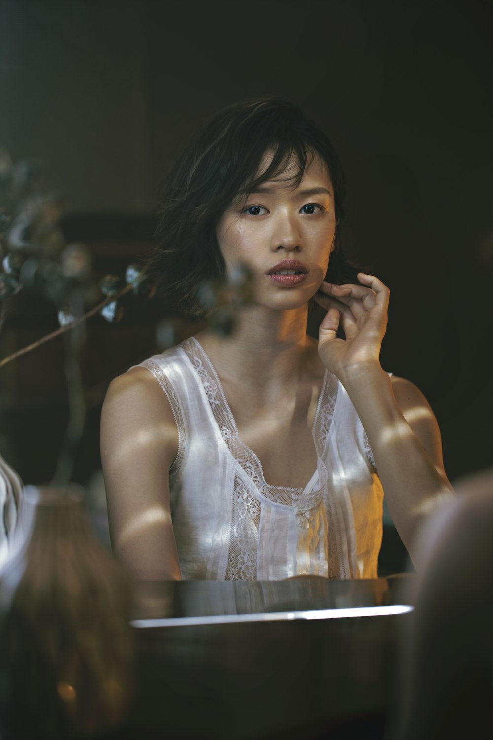 a woman sitting at a table talking on a cell phone