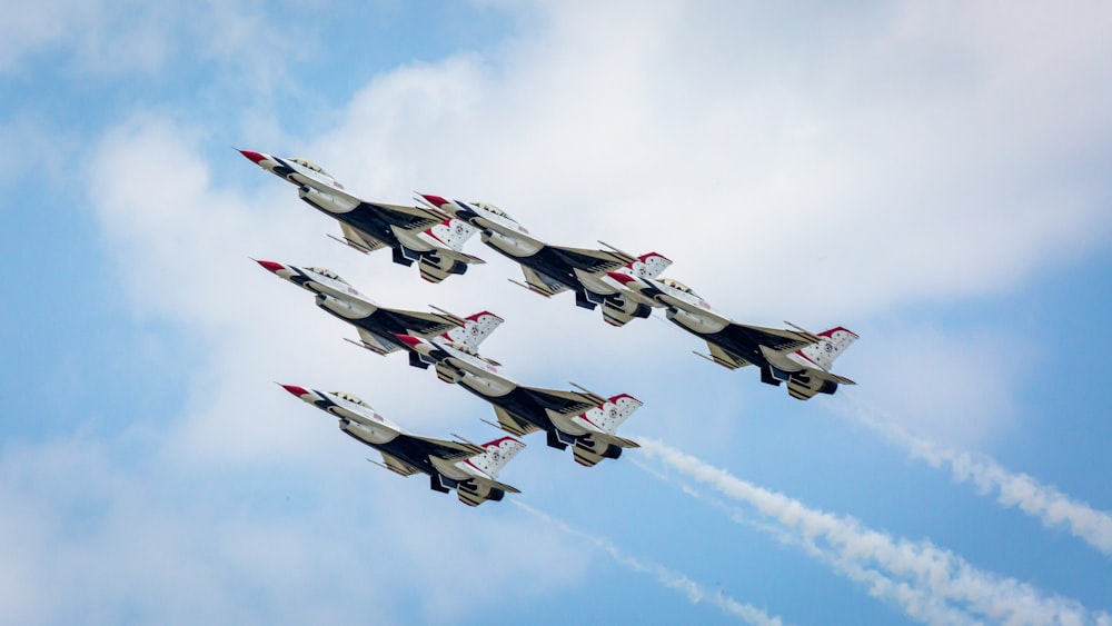 a group of fighter jets flying through a blue sky