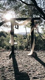 Softly lit floral archway at sunset, setting a romantic scene for the wedding ceremony.