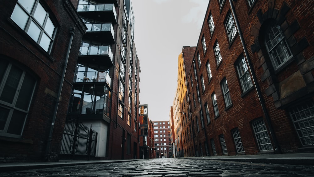 a cobblestone street lined with tall brick buildings