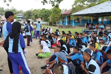 A group of young men and women from the barracks engaged in a community meeting outdoors.