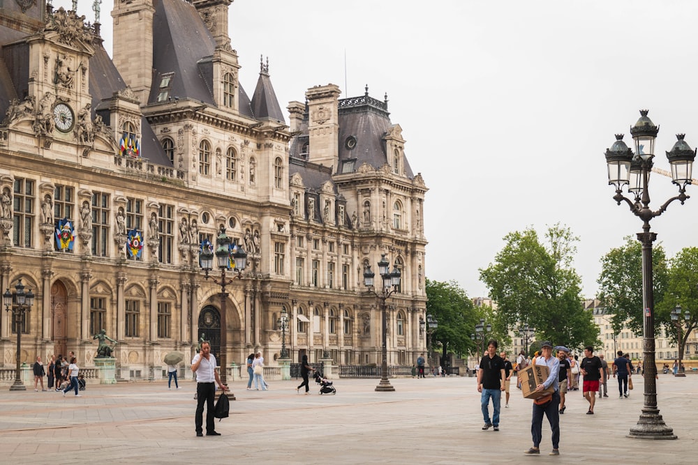 a group of people walking around a large building