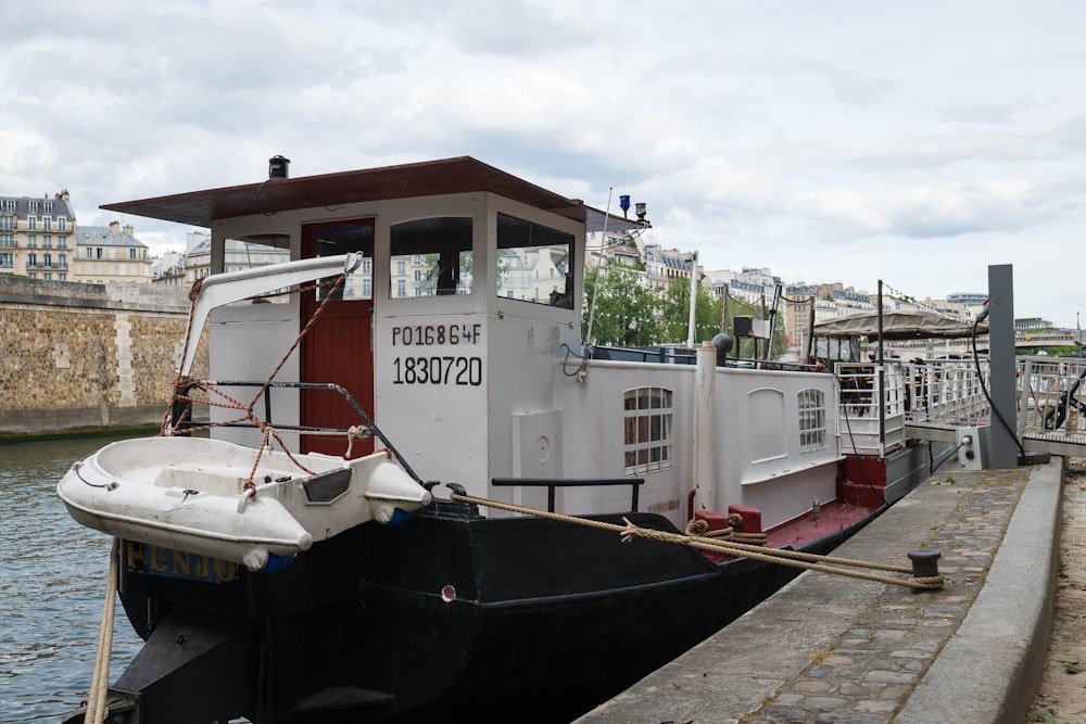 a white and black boat docked at a dock