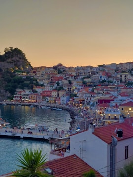 A vibrant coastal village with colorful boats docked by the shore at sunset.