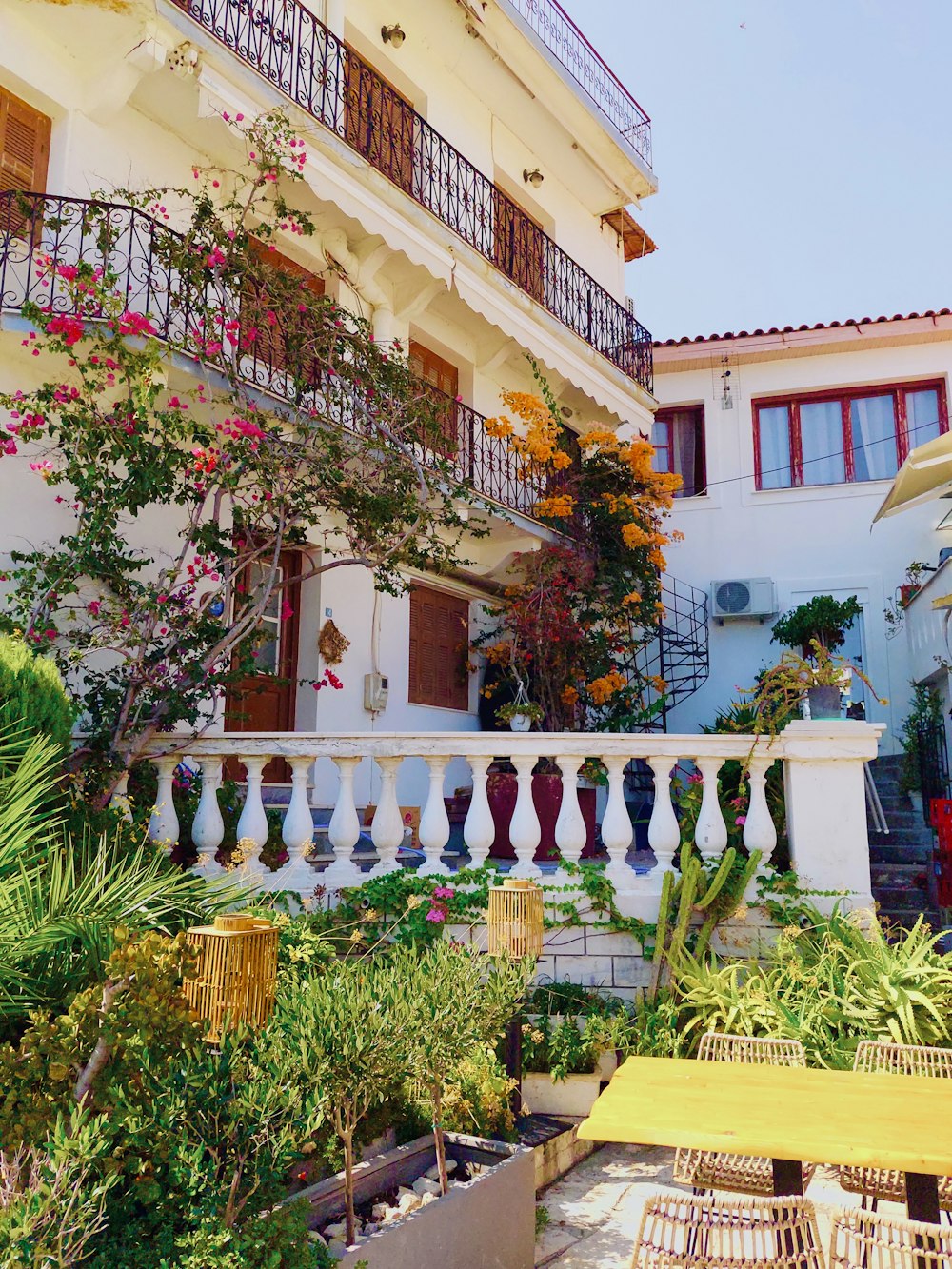 a balcony with a table and chairs in front of a building