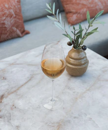 a glass of wine sitting on top of a marble table